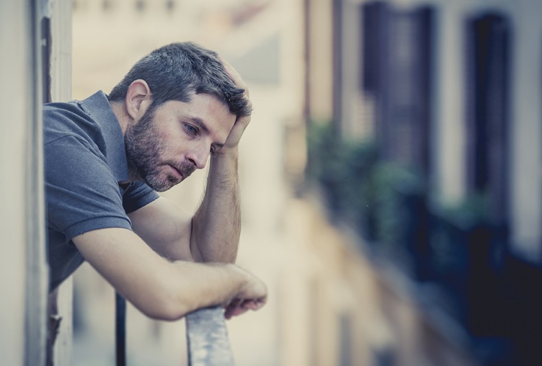 young man at balcony in depression suffering emotional crisis